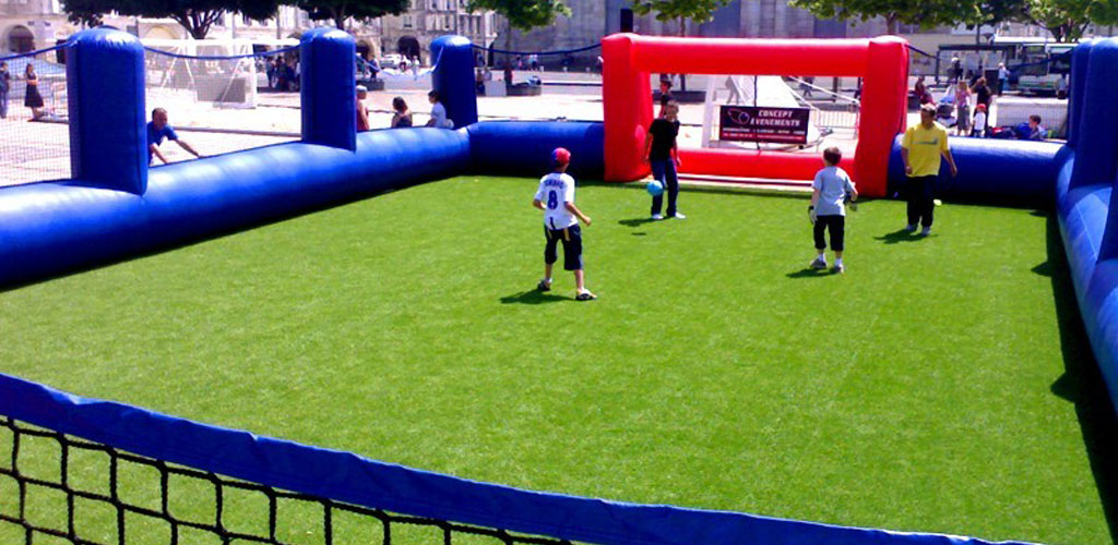enfants jouant sur un stade de foot en pelouse artificielle