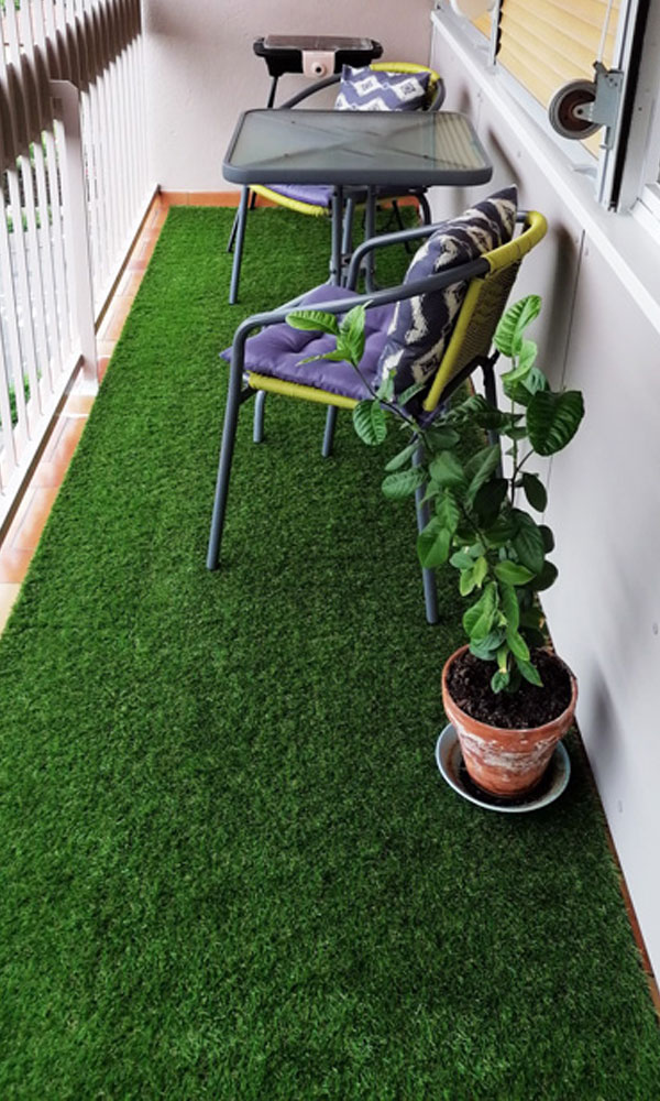 Terrasse confortable et colorée avec ce tapis en gazon artificiel.