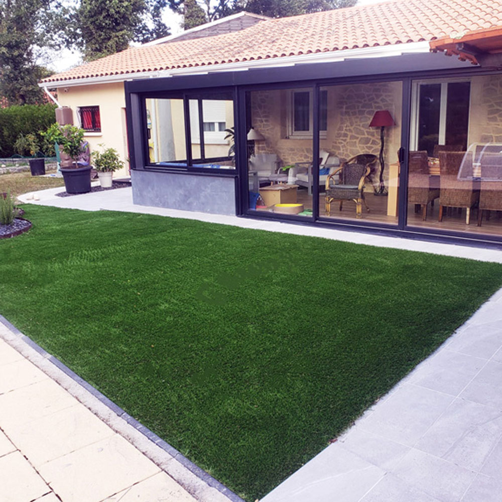 Aménagement patio d'une maison avec de la fausse pelouse