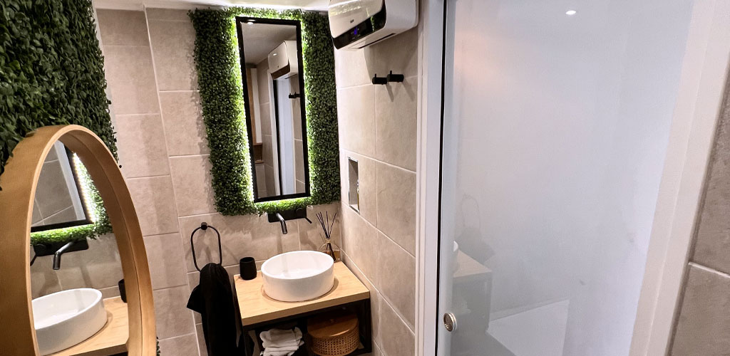 Bathroom decorated with a plant wall and artificial plants