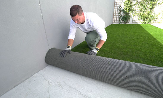 Man laying artificial grass