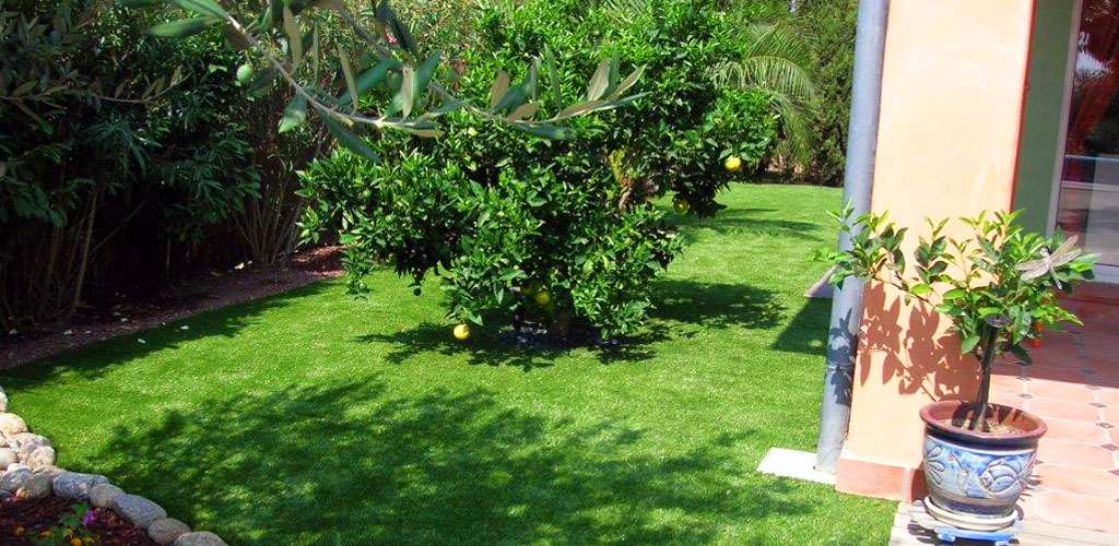 Artificial grass on a garden with a tree