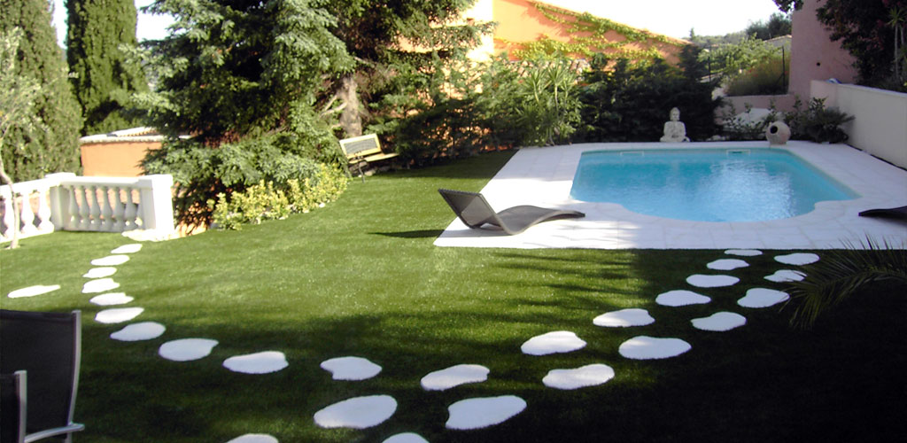 Jardin paysagé avec gazon synthétique et piscine